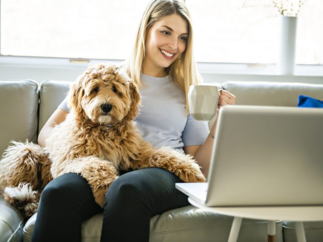 Woman sitting on couch with dog