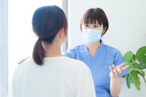 Provider with mask seeing patient