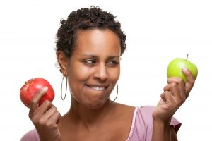 Woman holding two different apples
