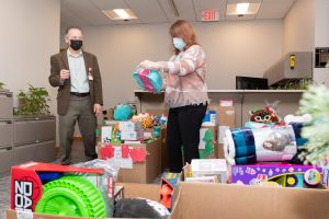 Deborah President and CEO Joseph Chirichella and Administrative Operations Director Cindy Durham sort donated toys while Hospital volunteers load up the truck.