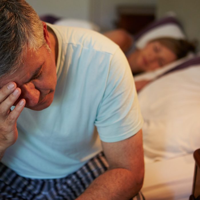 Man Awake In Bed Suffering With Insomnia Late At Night