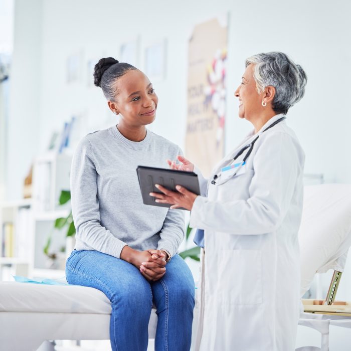 female doctor holding a tablet and talking to a patient