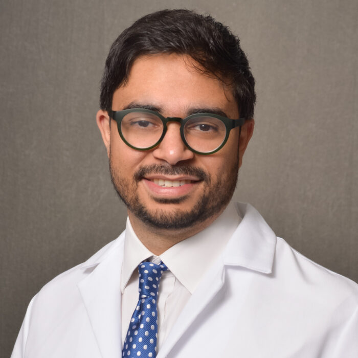male physician wearing dark rimmed glasses and lab coat