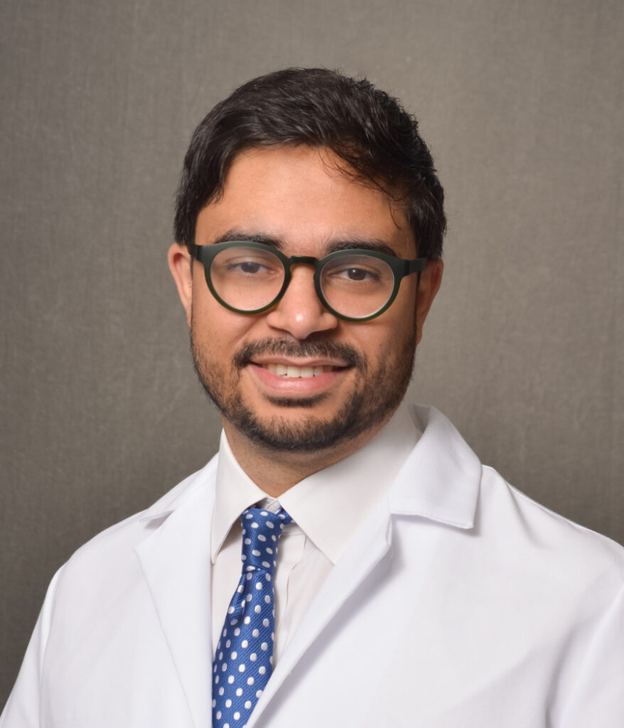 male physician wearing dark rimmed glasses and lab coat
