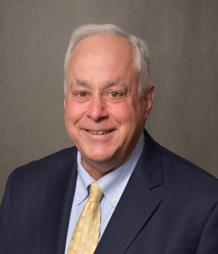 man in navy blue suit with yellow tie