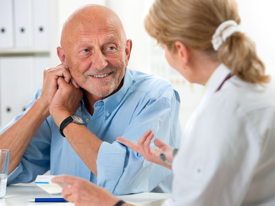 doctor talking to her male senior patient at office