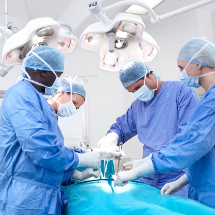 Medical surgeons performing surgery in an operating theatre together