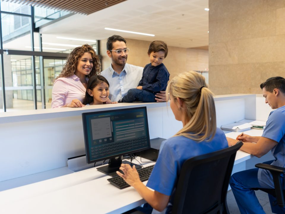 family registering for a doctor's appointment at the clinic front desk