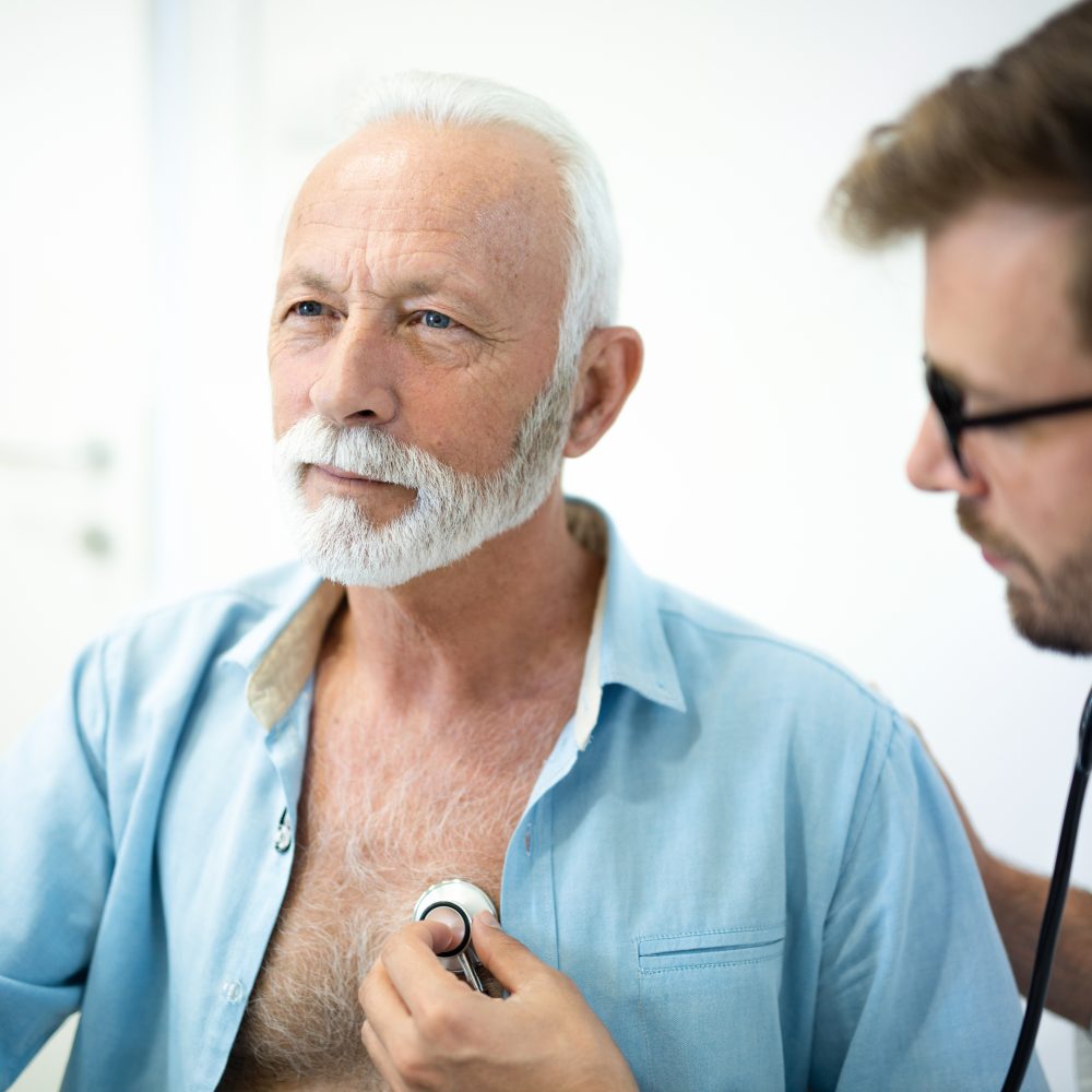 Senior man having his heart examined with stethoscope in hospital.