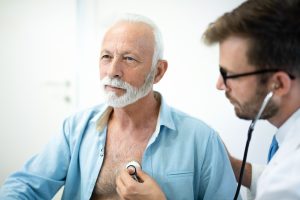 Senior man having his heart examined with stethoscope in hospital.