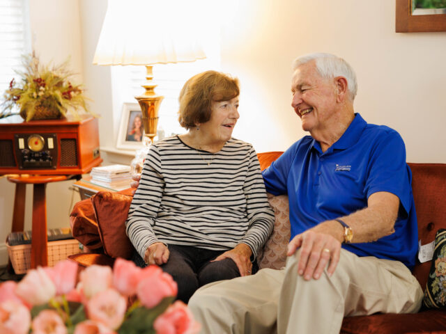 older couple sitting on red couch