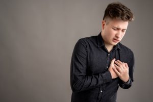 Portrait of serious stylish attractive man dressed with a casual black shirt has cardiac problem