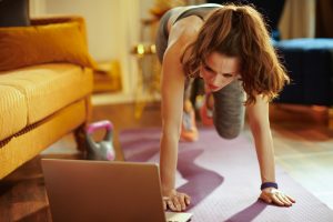 Woman exercising with laptop