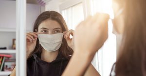 Young woman trying on a face mask