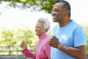 Older couple jogging while smiling