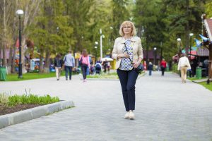 Woman walking down foot path in town