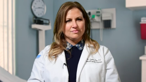 image of a female physician with long brown hair wearing a lab coat