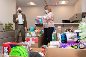 Deborah President and CEO Joseph Chirichella and Administrative Operations Director Cindy Durham sort donated toys while Hospital volunteers load up the truck.