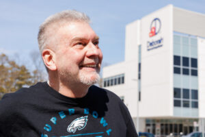 photo of man smiling in front of Deborah building