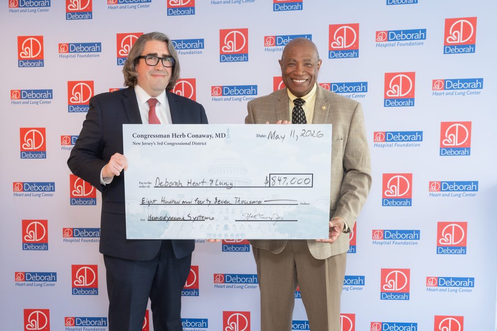 two men stand by side holding large check for $847,000