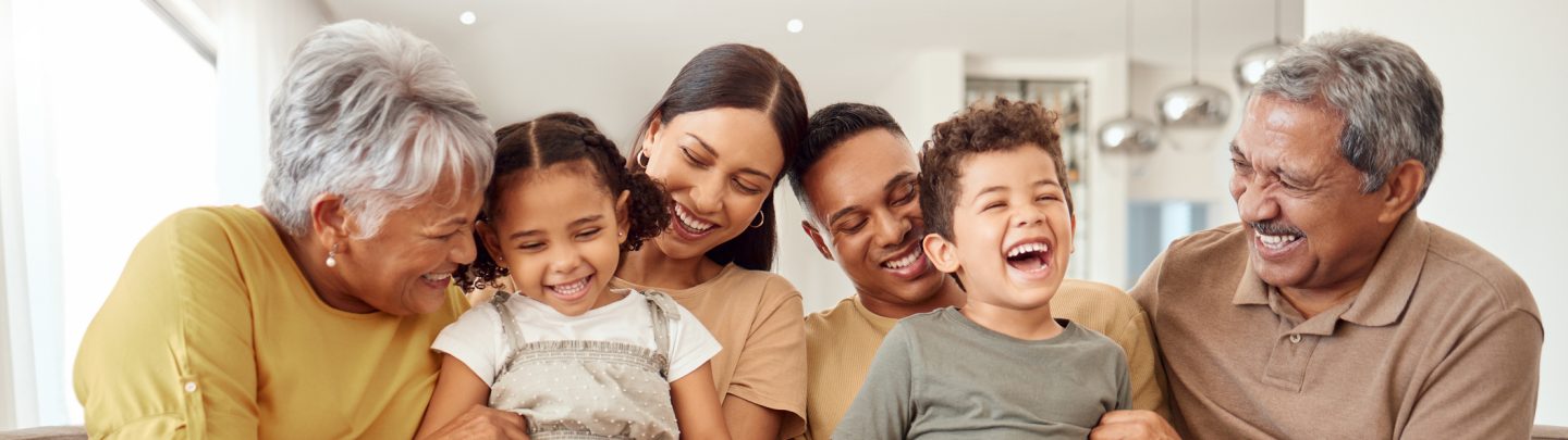 Happy, big family and quality time bonding of children, parents and grandparents together on a sofa. Laughing kids having fun with mom, dad and grandparent on a home living room couch with happiness