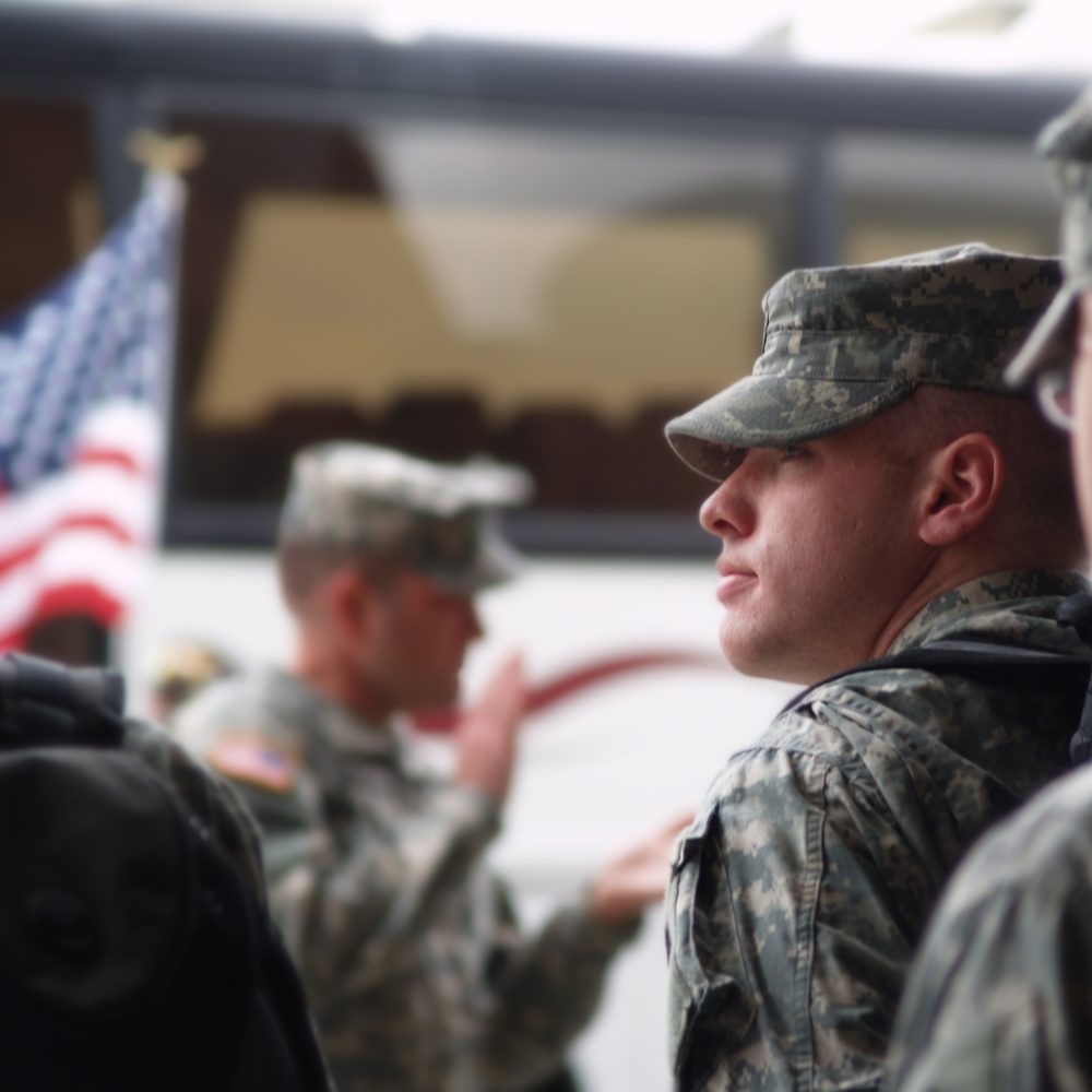 A soldier in formation preparing to board the bus and begin his deployment to War in Iraq.